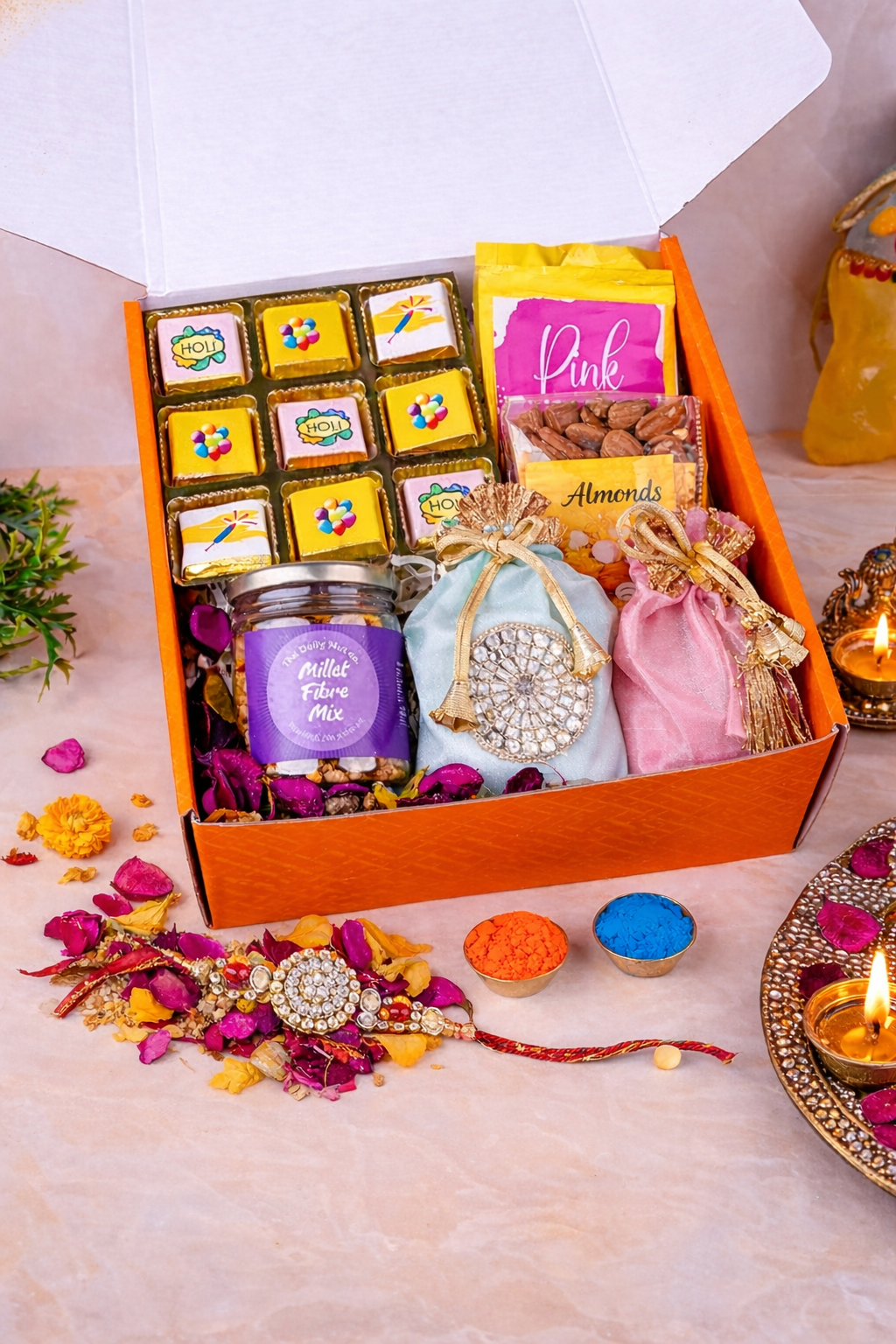 Luxury Raksha Bandhan gift hamper with designer rakhi, chocolates, dry fruits, sweets, and festive gift items arranged in an orange gift box.