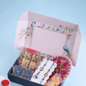 Premium Rakhi gift hamper with designer rakhis, baklava sweets, roli chawal boxes, decorative puja thali and festive gift packaging.